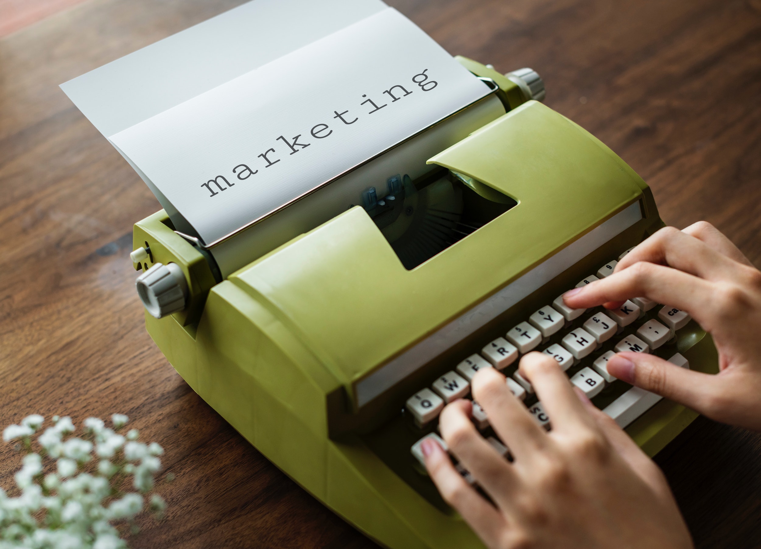 Person typing about content marketing on typewriter