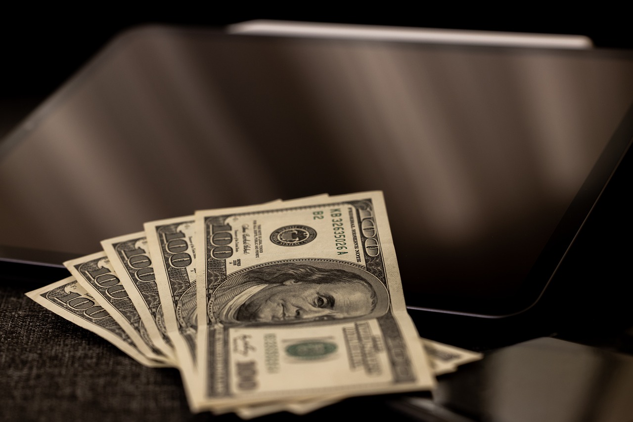 dollar bills on screen for account executive salary trends